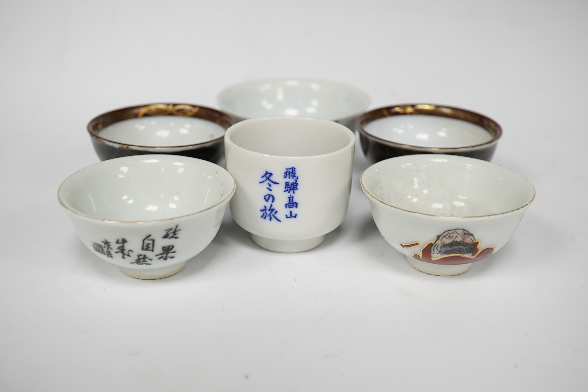 Six Japanese sake bowls, two pairs and two single, tallest 4cm. Condition - some chips